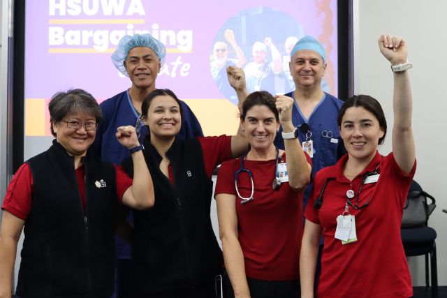 A group of Members at Hollywood private hospitals raise their fists in solidarity.